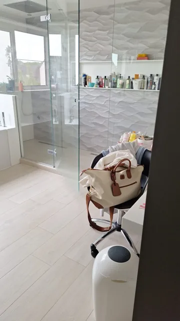 Glazen douchewand en tegelvloer in een badkamer