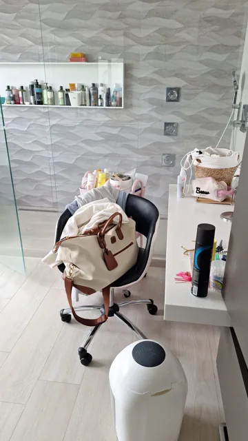 Badkamer met wandtegels, stoel en wastafel