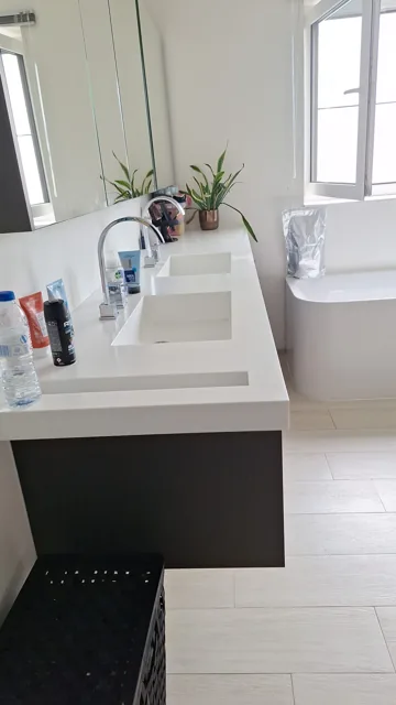 Dubbele wastafel naast het raam in een badkamer
