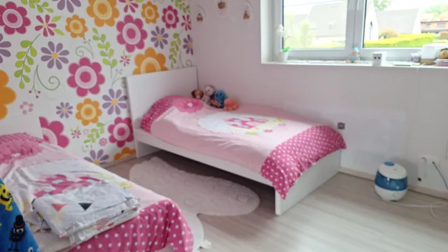 Twee opgemaakte bedden in een kleurrijke kinderkamer
