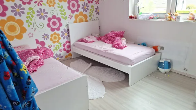 Kinderkamer met twee bedden en lichte vloer