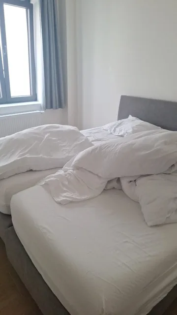 Slaapkamer met dubbel bed naast het raam